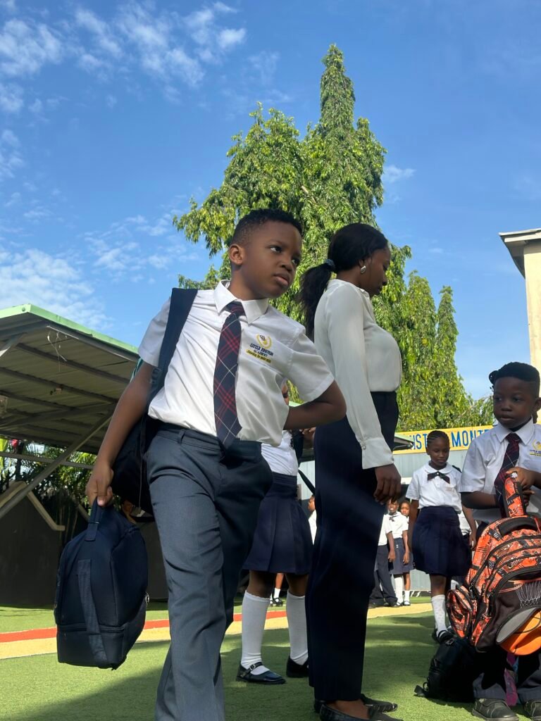 A pupil with his school bag arriving in the morning beside a member of staff