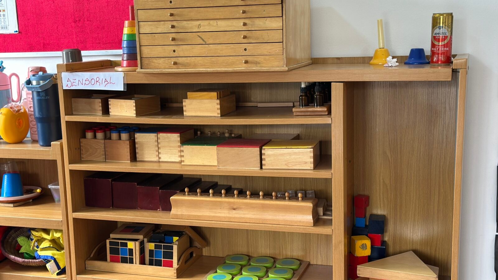 Montessori learning materials arranged on low wooden shelves