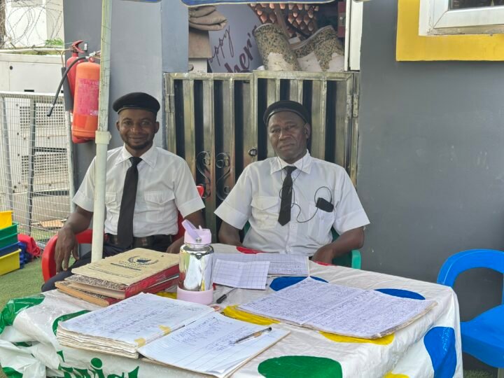 Two security officers at the sign-in desk by the school entrance